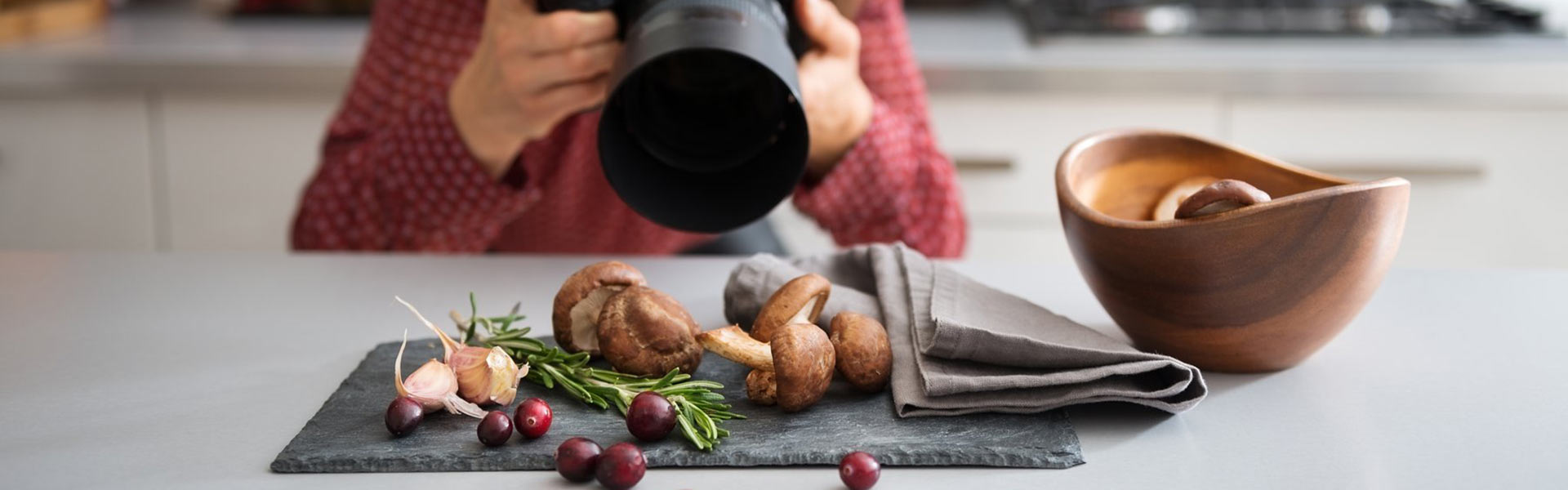 Food photographer taking photo of fresh produce on a board.