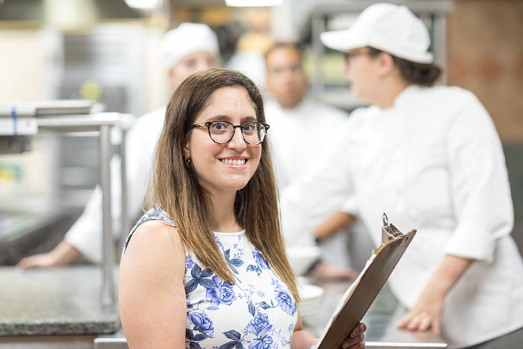 Image of Rebecca Rein, Graduate Admissions and Enrollment Counselor standing in a kitchen.