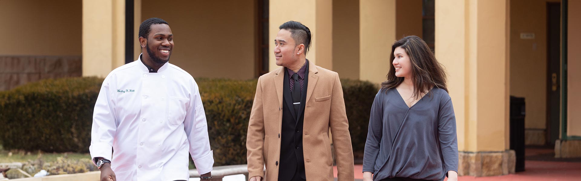 Image of three CIA students walking outside on campus.