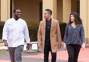 Image of three CIA students walking outside on campus.
